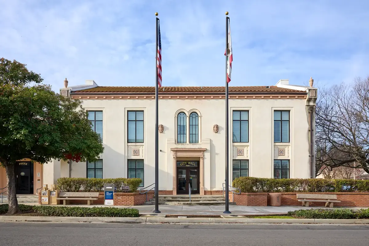 The historic Gridley City Hall building with flags out front