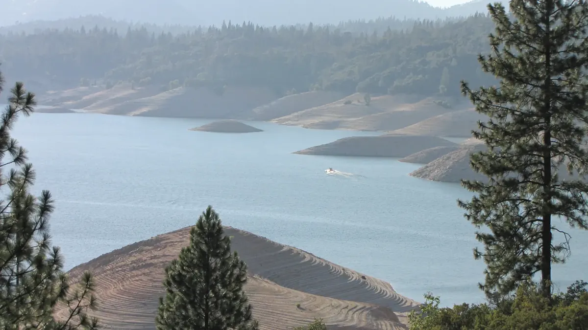 Lake Oroville dropped to a low level with wide bands of bare shoreline exposed